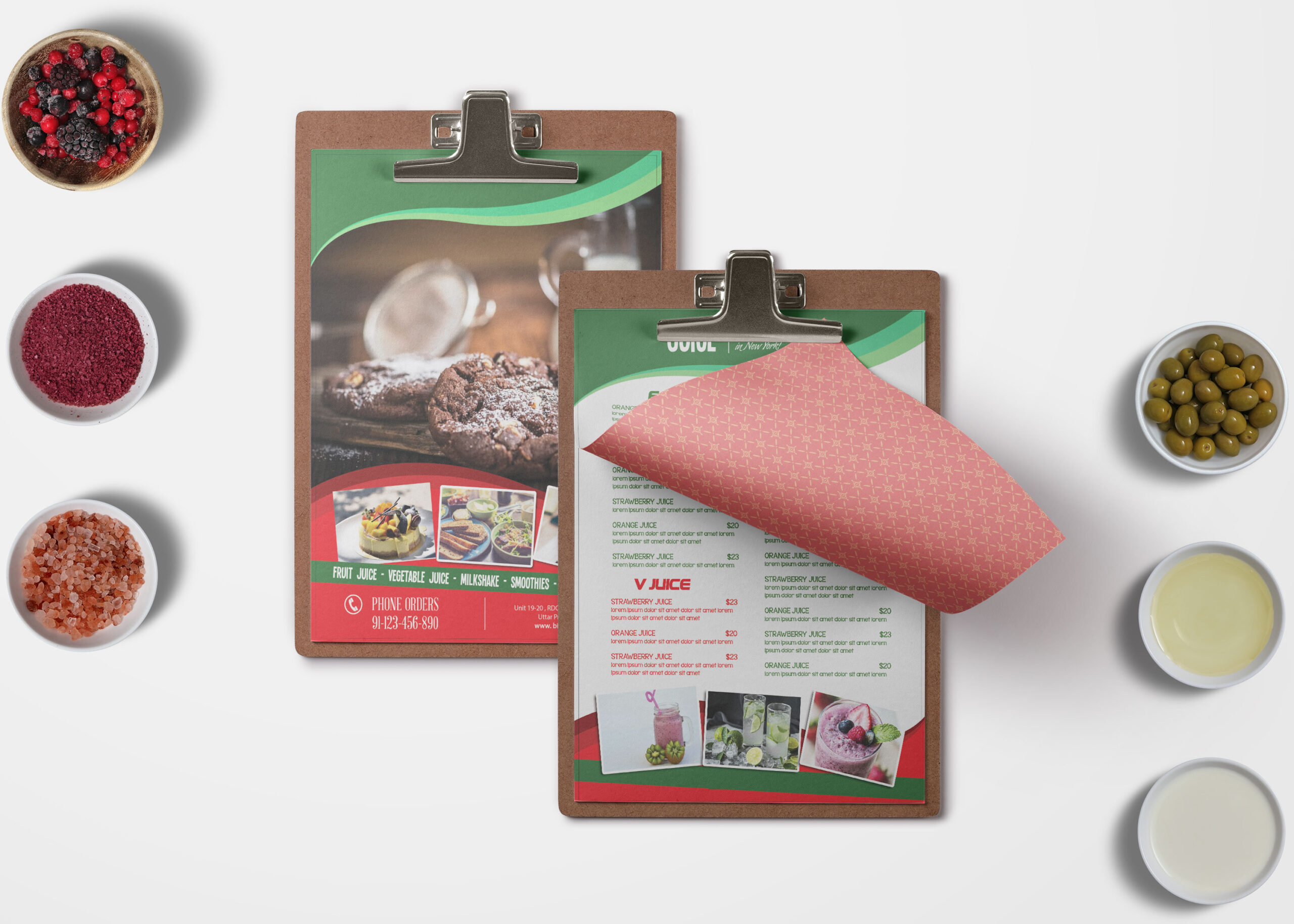 A bi-fold bakery menu on a clipboard, featuring images of baked goods, surrounded by bowls of ingredients and sauces.